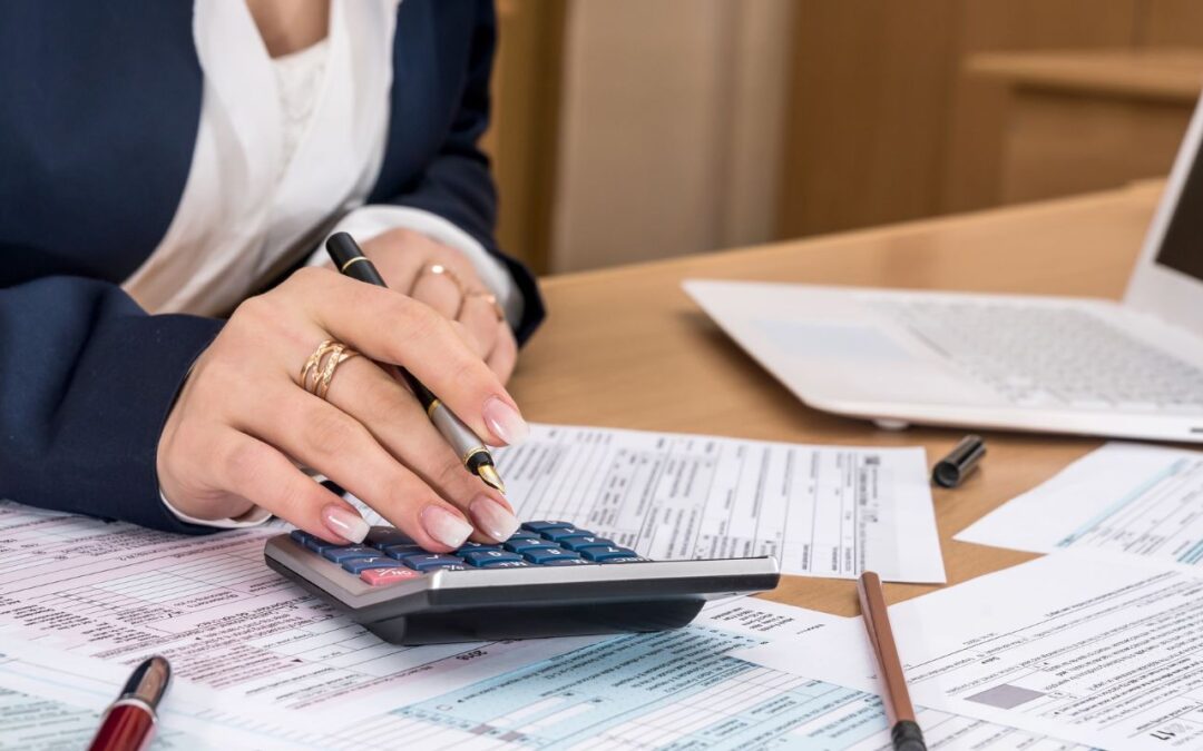 woman sitting down in front of pieces of paper doing taxes